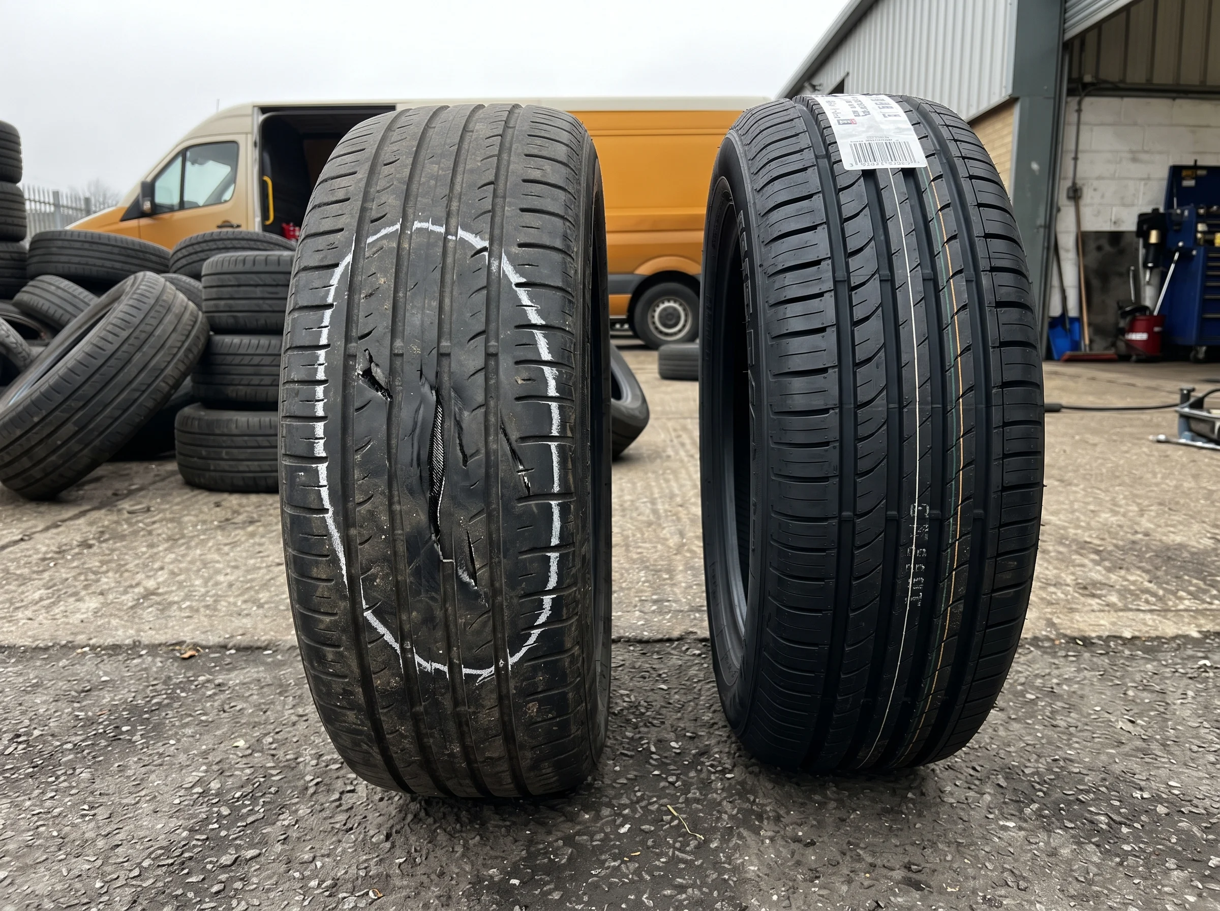 A refused tyre with sidewall damage circled in chalk, standing beside its new replacement